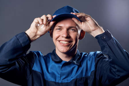 working man in uniform with a lamp in his hands electrician professionの写真素材