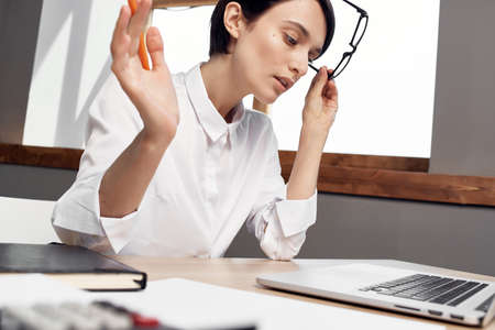 woman in costume in front of laptop with glasses self-confidence light background