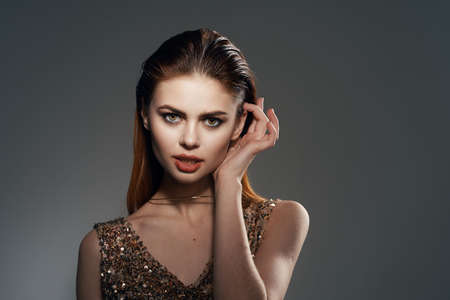 cheerful woman in a golden dress jewelry earrings fashion glamorの写真素材