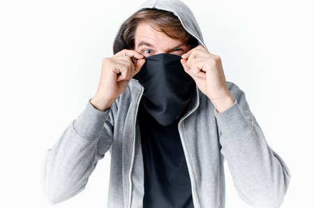 man hiding his face under a mask with a hood anonymity crime theft close-up