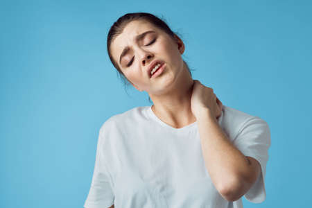 woman in white t-shirt health problems discontent blue backgroundの写真素材