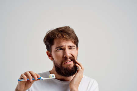 emotional man toothbrush in hand hygiene clean teeth light background