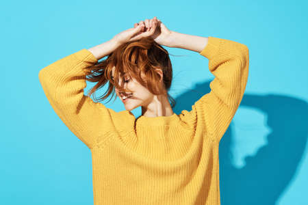 attractive woman in yellow sweater fashionable hairstyle emotions posingの写真素材
