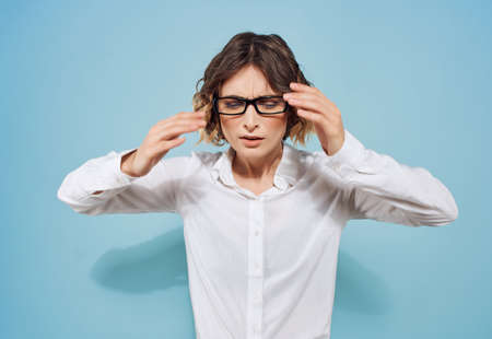 Business woman in white shirt and glasses working office blue backgroundの写真素材
