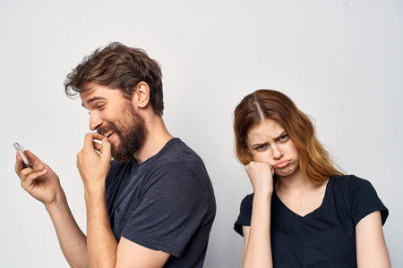 cheerful young couple in black t-shirts phone fun together friendship Studio Lifestyle