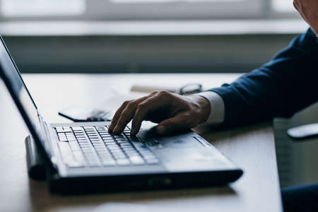 man in front of laptop at the table in front of a laptop communication success