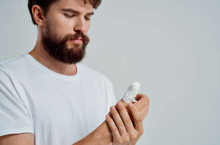 male patient hand injury treatment health problems light backgroundの写真素材