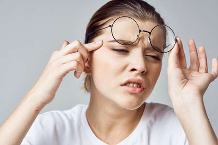 woman in white t-shirt glasses poor eyesight close-upの写真素材