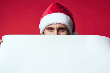 Cheerful man in a santa hat holding a banner holiday isolated backgroundの写真素材