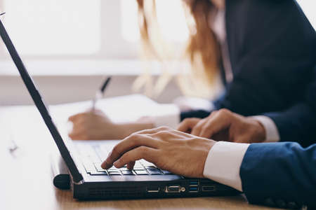 managers sitting at a desk with a laptop communication finance officials