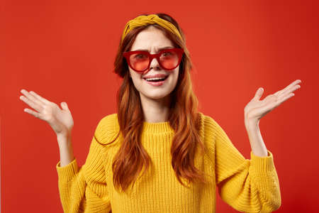 pretty woman in yellow sweater red glasses studio fashion posing
