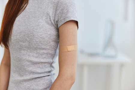 woman with adhesive plaster on shoulder health immunity covid-19 passportの写真素材