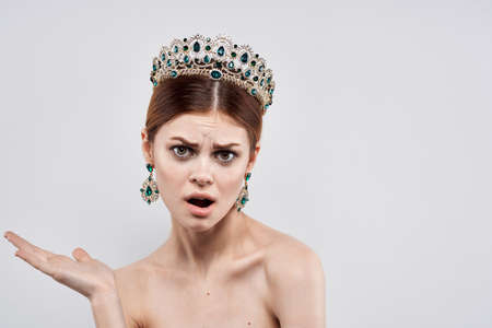 beautiful woman naked shoulders jewelry cosmetics attractive look light backgroundの写真素材