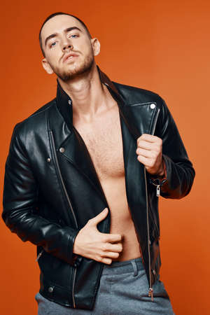 handsome man in leather jacket pumped up torso fashion studio isolated background