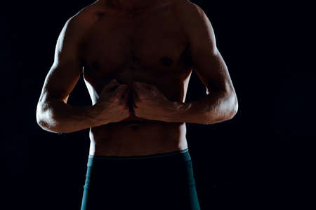 man with muscular abs cropped view of gym dark backgroundの写真素材