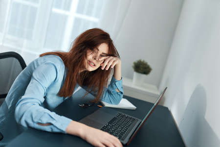 woman sitting at a table in front of a laptop learning disorder fatigue