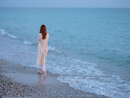 woman walking by the ocean rest freedom romanceの写真素材