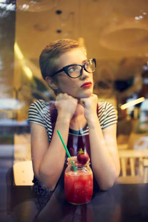 woman with short hairstyle in a cafe cocktail rest pensive lookの写真素材
