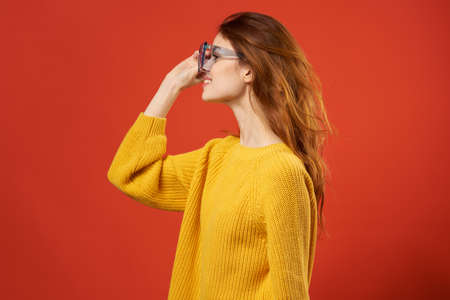 pretty woman in yellow sweater blue glasses fashion hairstyleの写真素材