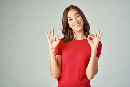 pretty brunette holding her hair red t-shirt studio modelの写真素材