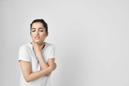 woman in a white t-shirt pain in the neck health problemsの写真素材