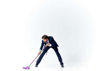 business man in a suit with a mop in his hands providing services cleaning floorsの写真素材