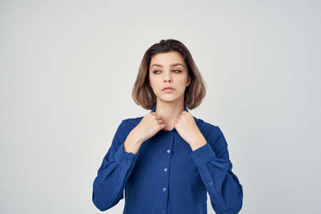Business woman in blue shirt emotions posing light backgroundの写真素材