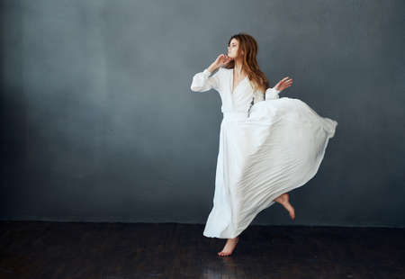 woman barefoot in white dress dancing on isolated background romanceの写真素材