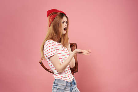 fashionable woman in red hat backpack in hands posing fashion
