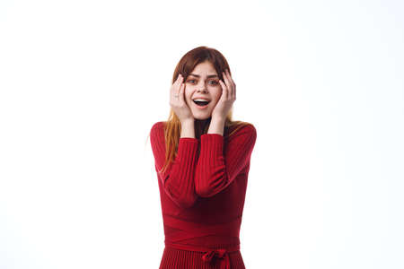emotional woman in red dress gesturing with hands light background