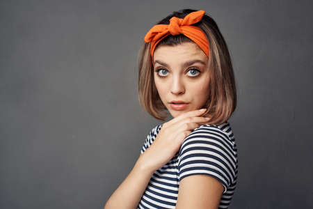 pretty fashionable woman with orange headband red skirt posingの写真素材