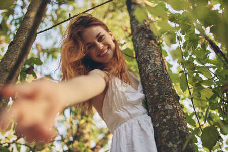 joyful woman in white dress near tree nature summerの写真素材