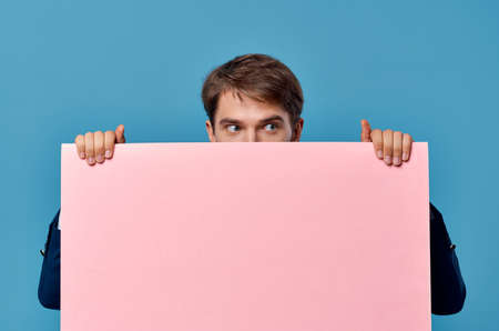 Cheerful man pink banner in hand blank sheet presentation copy-space studioの写真素材