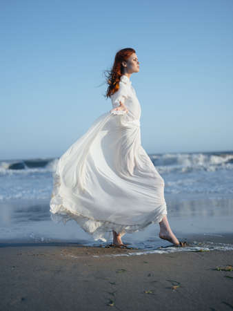 pretty woman in white dress by the ocean posing vacationの写真素材