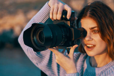 woman with camera in nature taking pictures of landscape Professionalの写真素材