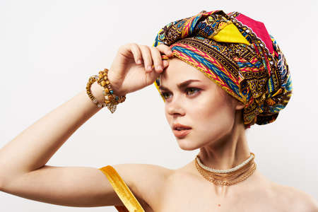 cheerful pretty woman in multicolored turban african style and fashion posingの写真素材
