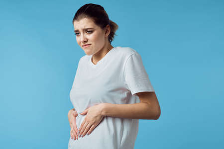 woman in white t-shirt health problems discontent blue backgroundの写真素材