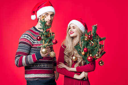 a man and a woman are standing next to Christmas decorations fun holidayの写真素材