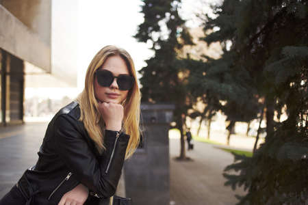 woman wearing sunglasses outdoors near building walk fashion glamorの写真素材