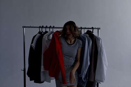 emotional woman selection of clothes near the wardrobe studio lifestyleの写真素材