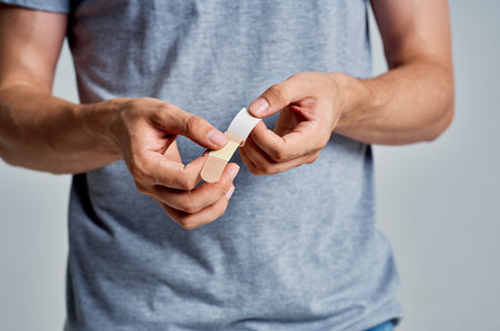 man holding plaster in hands treatment helpの写真素材