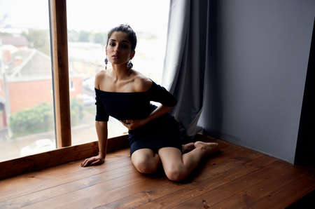 pretty woman near window posing attractive look earrings elegant styleの写真素材