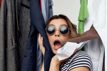 pretty woman with glasses next to clothes fashion fun emotionsの写真素材