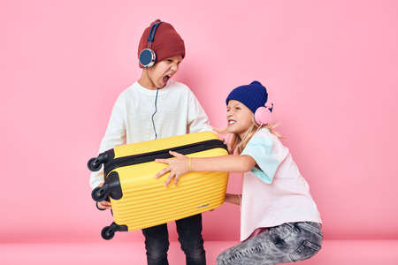 adorable little kids yellow suitcase with headphones Childhood lifestyle conceptの写真素材
