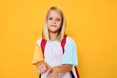happy schoolgirl blonde hair school backpack posing education conceptの写真素材