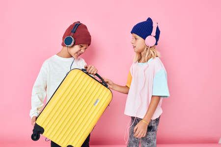 funny little boy and girl stylish clothes suitcase headphones Childhood lifestyle conceptの写真素材