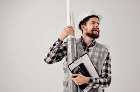 male builder with documents and drawings blueprints light backgroundの写真素材