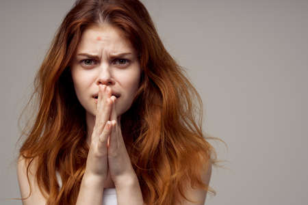 pretty woman in a white t-shirt pimples on the face light backgroundの写真素材