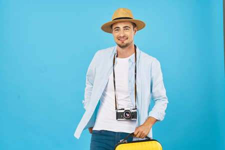 man with camera and hat on blue background cropped view