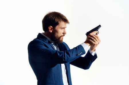 man in a suit with a gun in hand light backgroundの写真素材